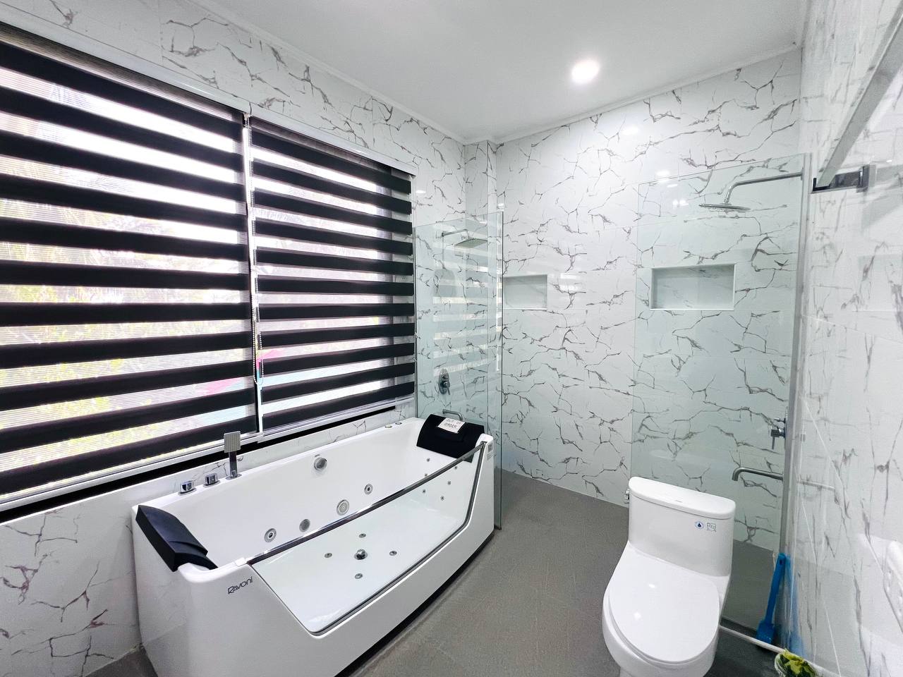 Marble bathroom in Grande Superior with a jetted tub beside the window