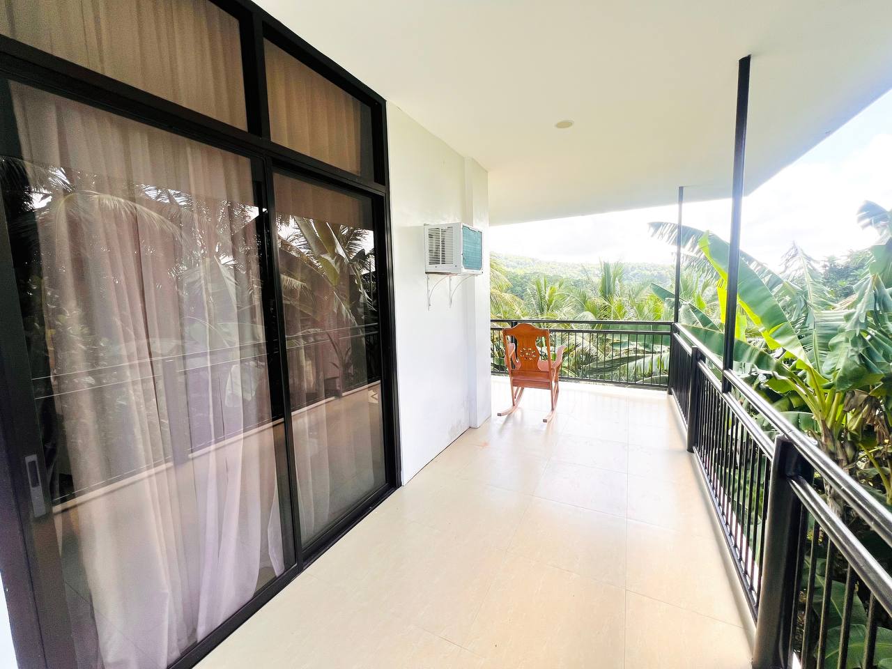 Sliding doors opening from the Modern Villa onto a balcony above the banana grove